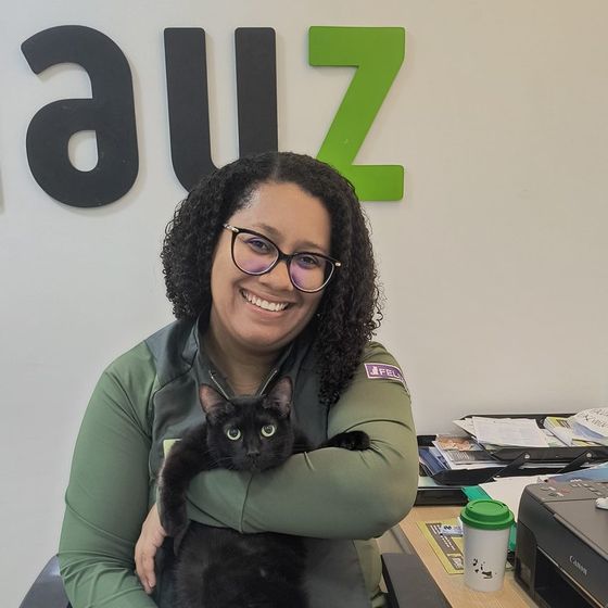 Veterinária Paloma Coutinho, da Miauz, com um gato preto no colo